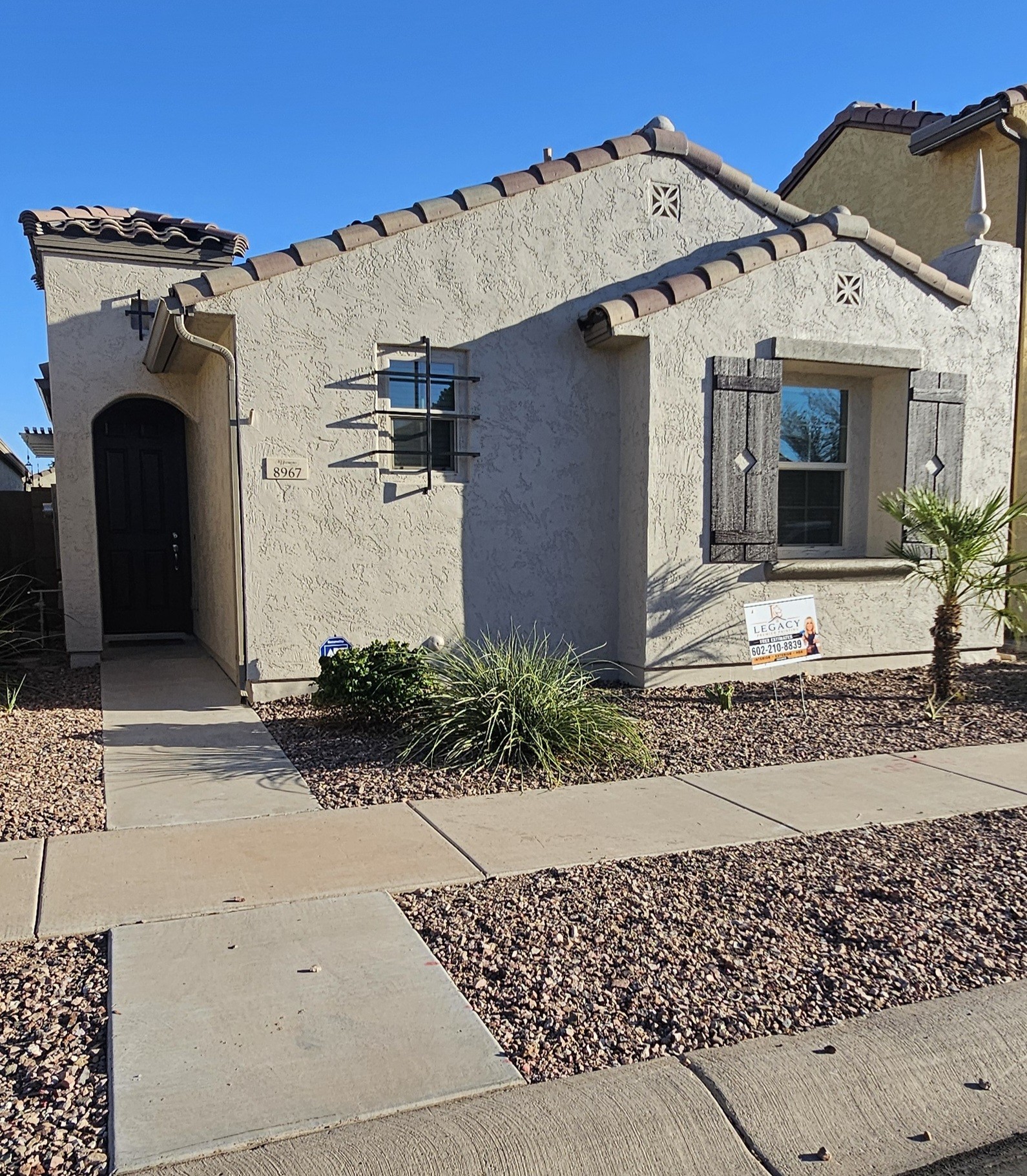 Freshly painted stucco home with Legacy Premier Painting sign